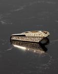 Moody lighting on a geometric diamond ring by Bena Jewelry, crafted in Montreal in 14k yellow gold with pavé diamonds, shown on black backdrop.