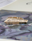 Gold and diamond ring with graphic lines by Bena Jewelry, Montreal-based designer, shown on a bold color backdrop for a contemporary look.