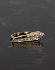 Architectural diamond ring in rich yellow gold by Bena Jewelry, glowing under soft shadows on a dark background, showcasing modern design details.