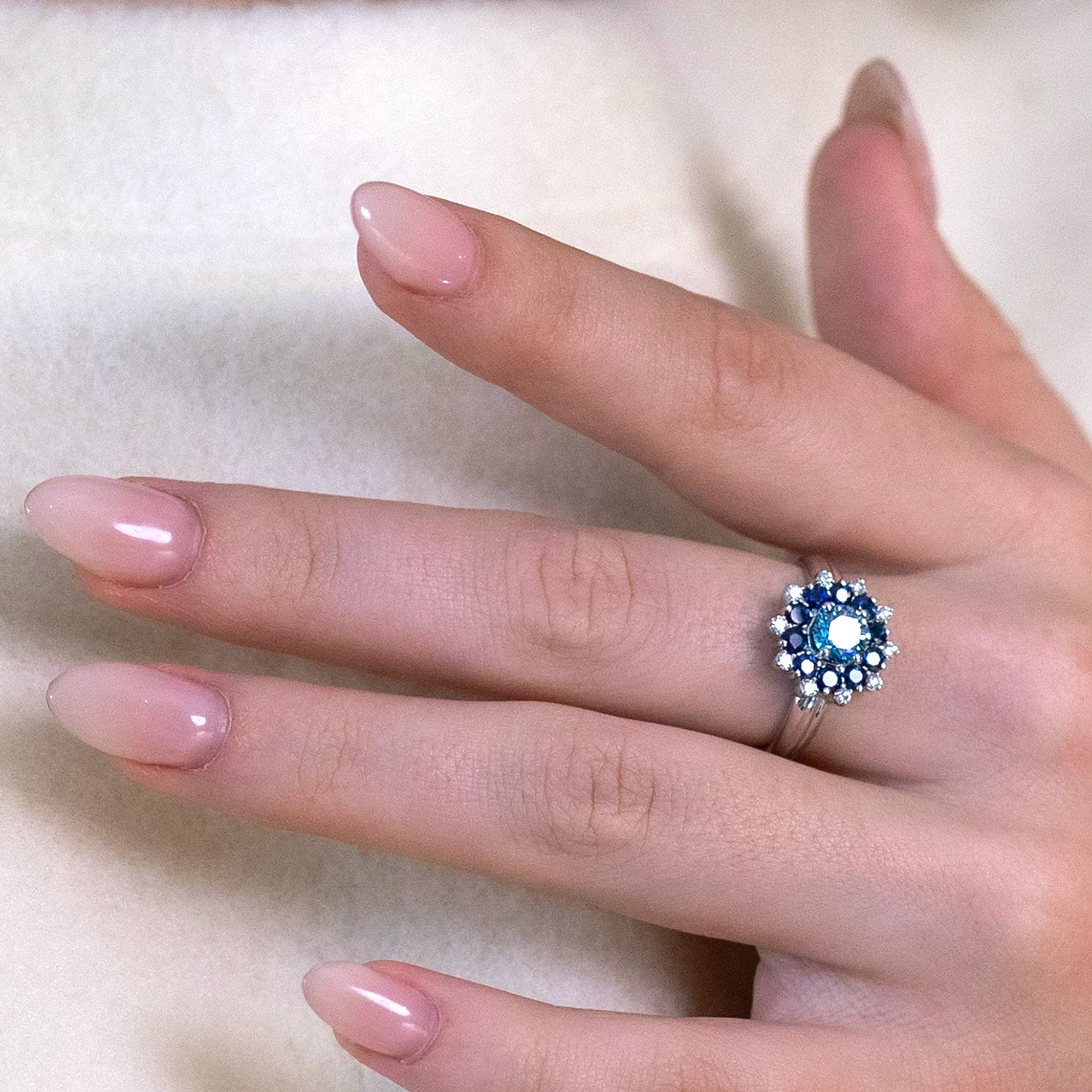 Close-up of the Soleil Ring worn, highlighting its intricate sapphire and diamond halo design, handcrafted in Montreal.