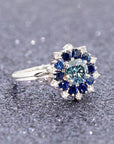 Soleil Ring on sparkly background, custom-made white gold design with lab-grown blue diamond and diamond accents.