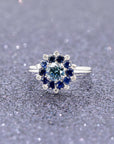 Elegant display of Soleil Ring by Bena Jewelry, bold white gold creation with sapphire and blue diamond details.