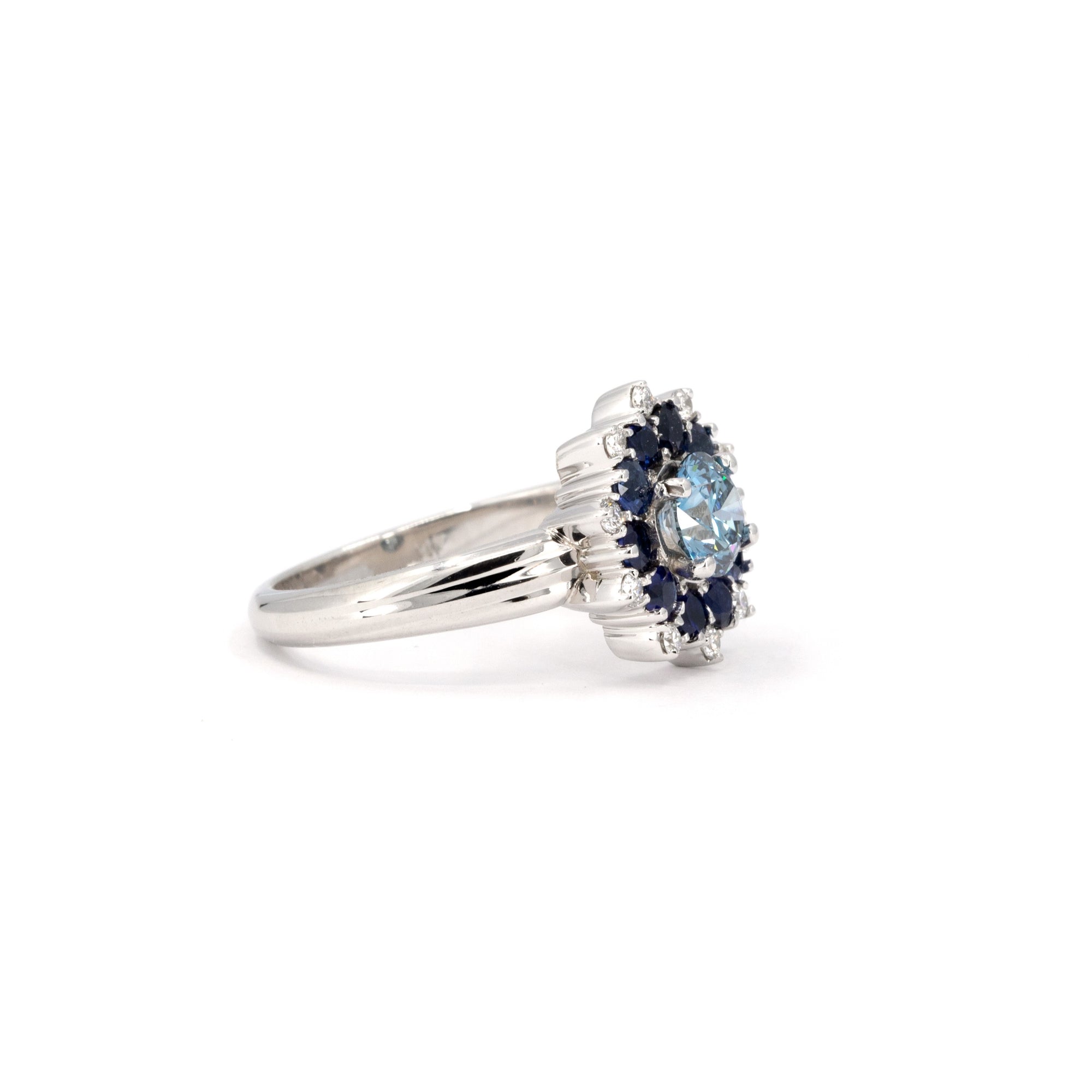 Soleil Ring close-up, showcasing custom-set blue diamond and sapphire halo in white gold, handcrafted in Montreal by Bena Jewelry.