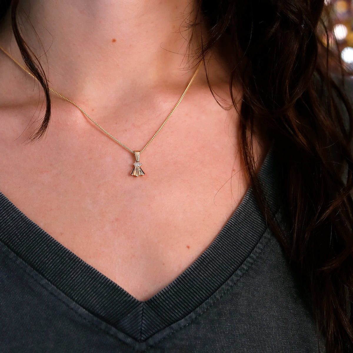 Delicate yellow gold necklace featuring a marquise diamond pendant, styled on a model. This elegant fan-shaped design showcases the artistry of independent local brand Bena Jewelry, perfect for a sophisticated look.
