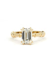 Emerald-cut diamond engagement ring in yellow gold with a milgrain band, handmade by Bena Jewelry in Montreal.