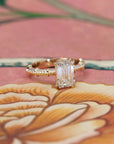 Close-up of the vintage-inspired engagement ring with an emerald-cut diamond and a finely detailed gold band.