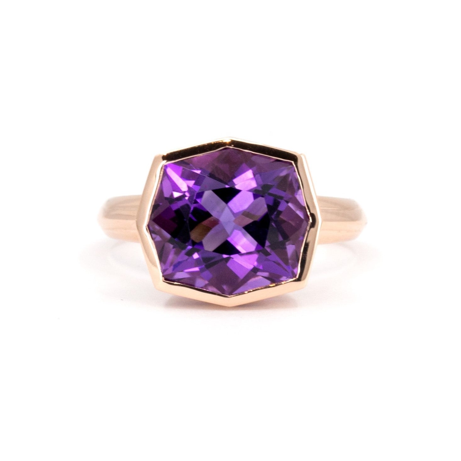 Deep purple amethyst ring in rose gold with an octagonal cut, bezel-set and elegantly displayed on a white background.