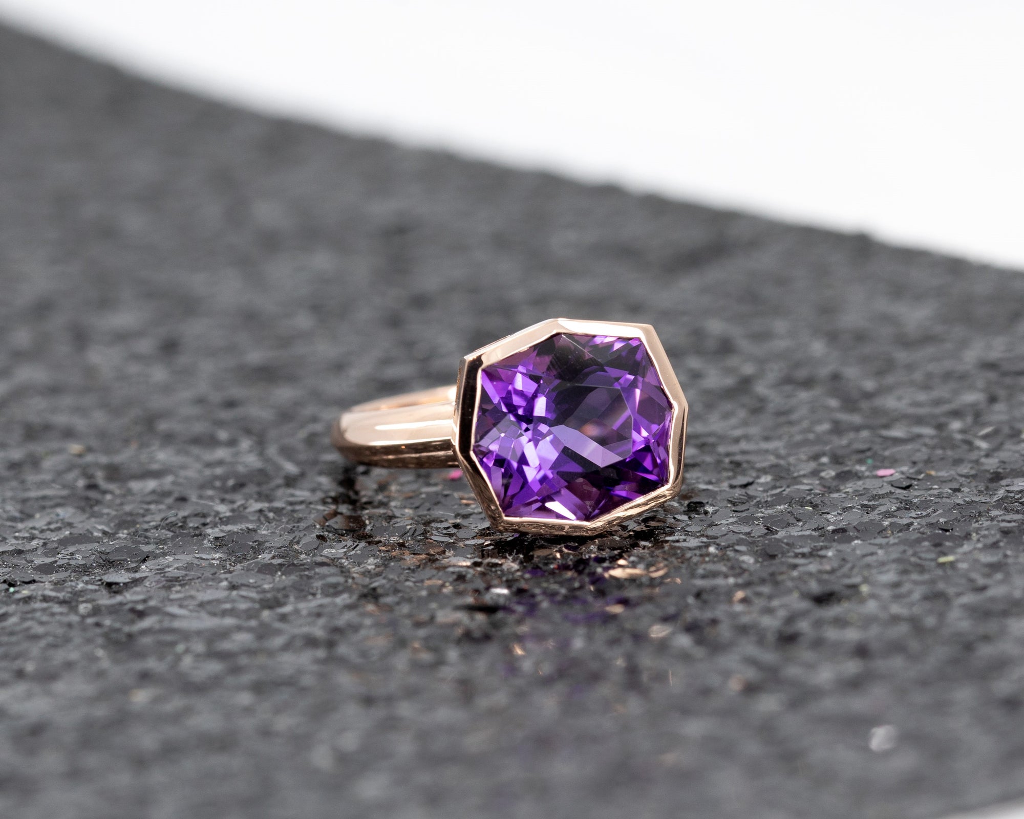 Fancy Edgy cocktail ring featuring a bezel-set Brazilian amethyst, set against a dramatic dark glitter surface.