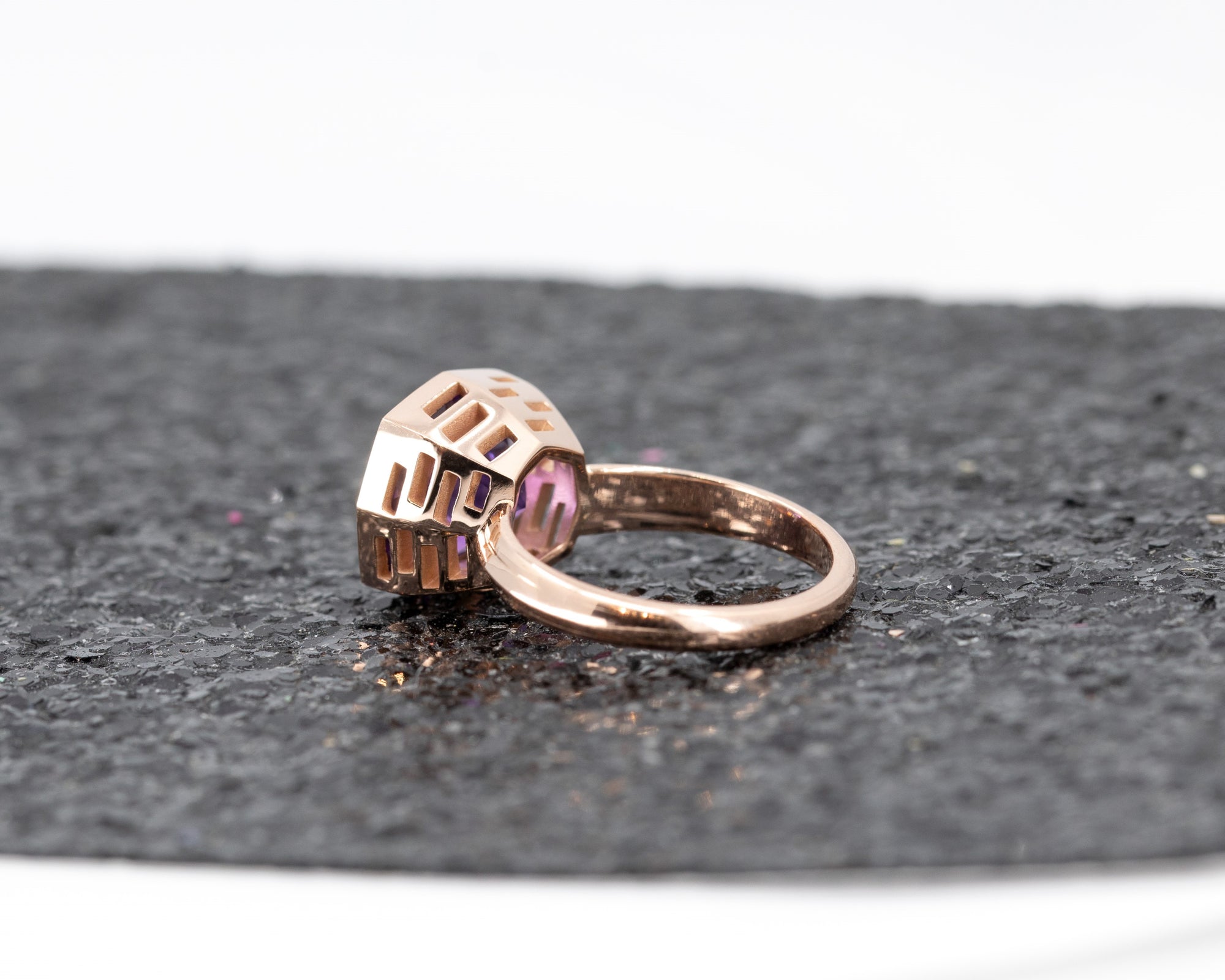 Back view of the statement Brazilian amethyst ring with a deep purple tone, surrounded by a luxurious dark glitter backdrop.