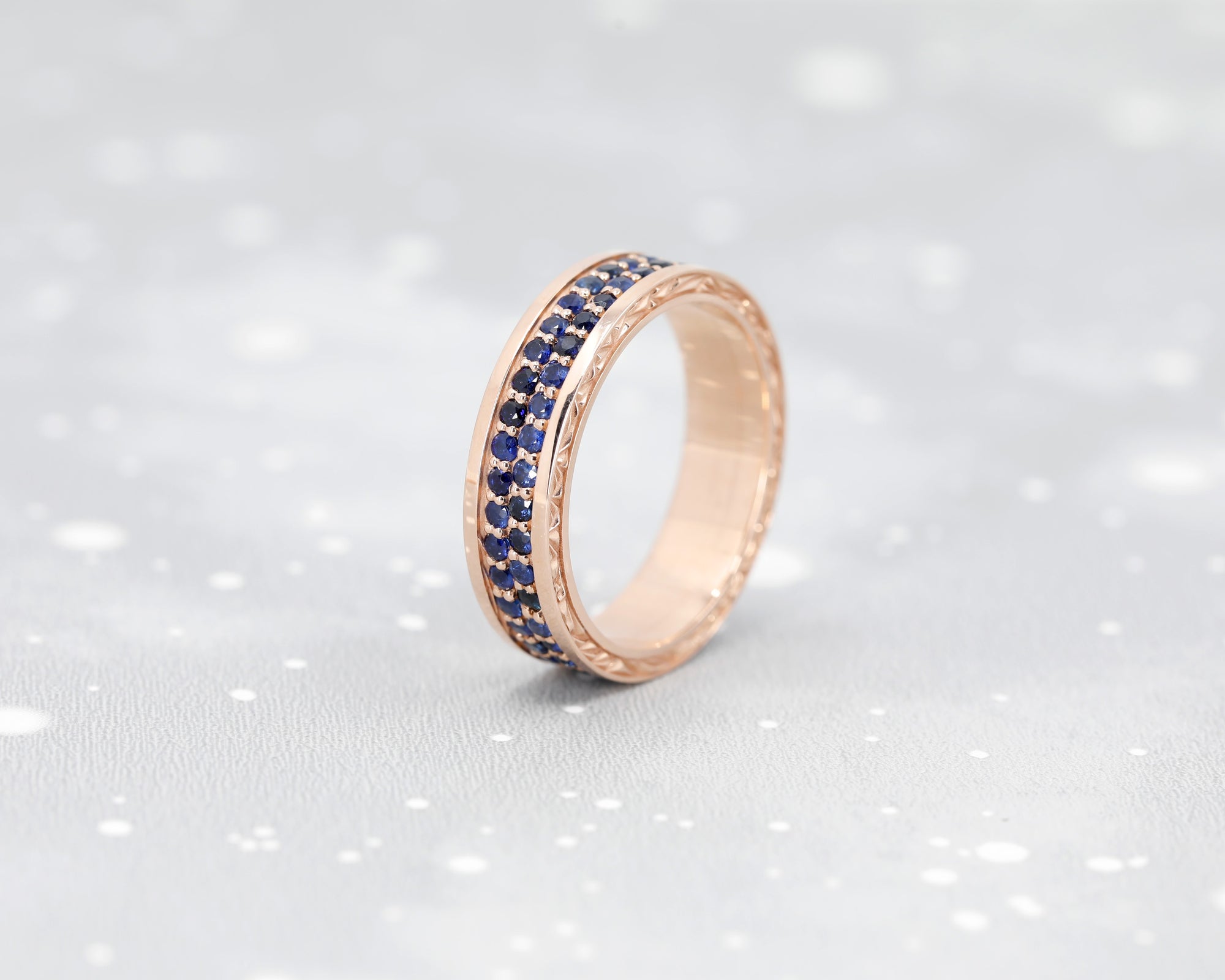 Bold men’s wedding band with blue sapphire pavé in rose gold, Chiseled design by Montreal-based Bena Jewelry.