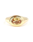 Close-up of a yellow gold ring with an oval champagne sapphire in a bezel setting, designed by Bena Jewelry in Montreal, Canada.