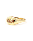 Side view of a fine yellow gold ring with a bezel-set oval champagne sapphire, handmade in Montreal by Bena Jewelry.