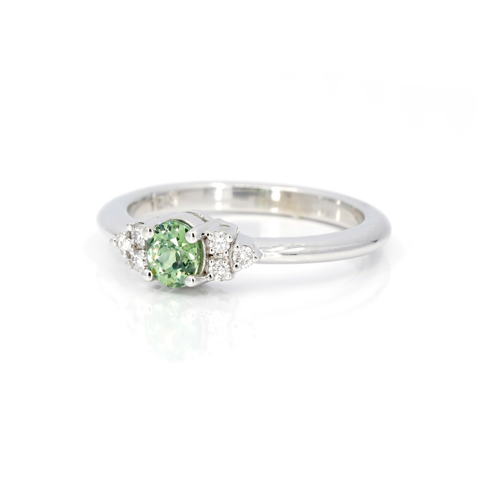 Oval green garnet and diamond wedding ring in white gold by Bena Jewelry displayed on a clean white background unique bridal ring made in Canada