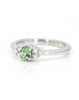 Oval green garnet and diamond wedding ring in white gold by Bena Jewelry displayed on a clean white background unique bridal ring made in Canada
