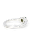 Back view of a white gold engagement ring featuring an oval green garnet and diamonds crafted by Bena Jewelry photographed on a white background.