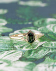 Close-up of the Adorn Hexagonal Green Sapphire Ring’s hexagonal sapphire, with intricate detailing on the yellow gold band. Made by Bena Jewelry, a bespoke creation from Montreal, Canada.
