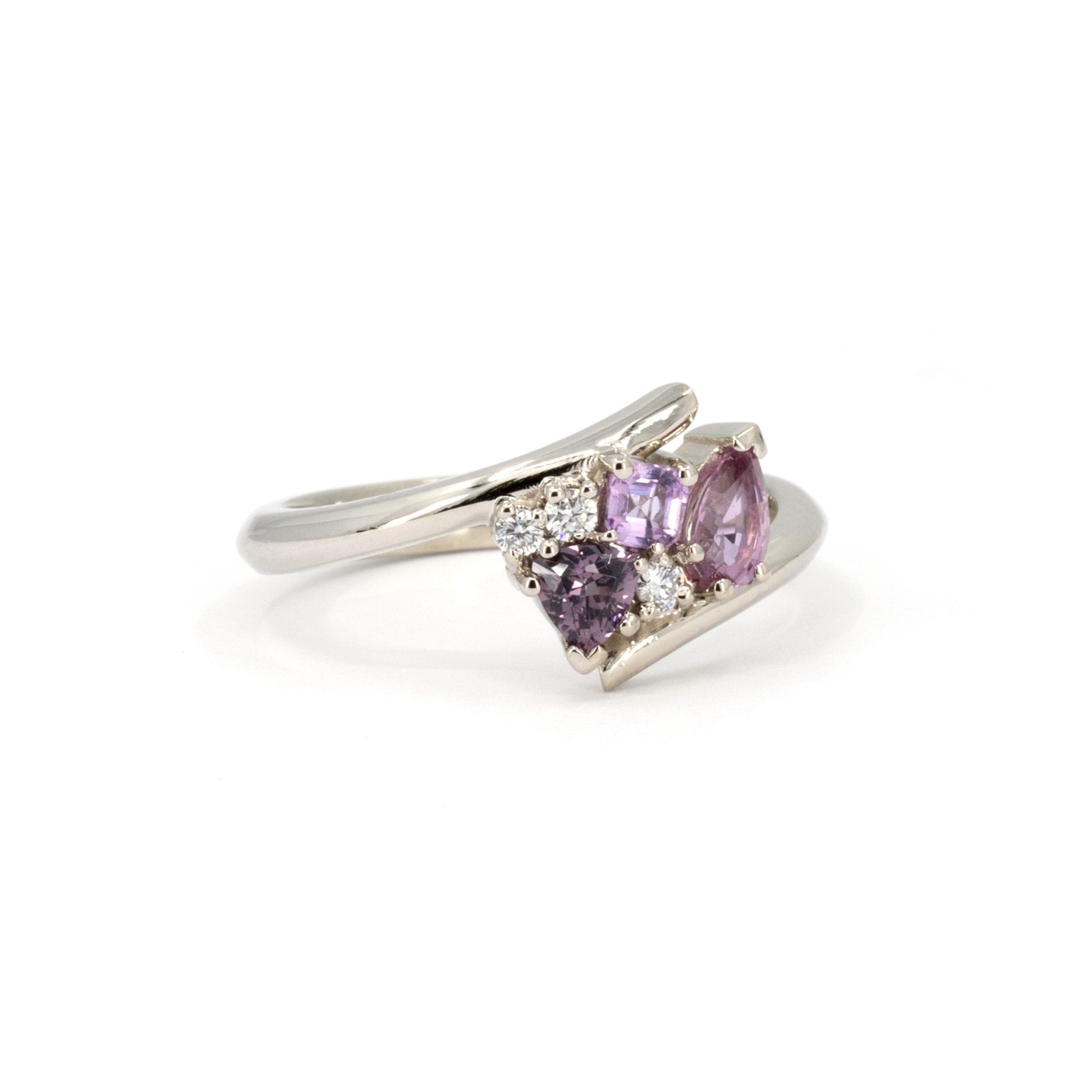 Close-up of Bena Jewelry's Kink Avalanche white gold ring, highlighting the vivid purple and pink sapphires in various cuts and sparkling diamonds, set against a white background.