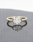Yellow gold ring featuring a marquise diamond, diamond accents, and royal blue sapphires, designed by Bena Jewelry, displayed on a black matte background.