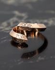 Close-up of the Loop Ring in rose gold, featuring diamond pave and a robust design on a sleek dark background. Made in Montreal by Bena Jewelry.