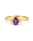 Desir Ring with an oval purple-pink sapphire and diamond accents, set in yellow gold. A handcrafted engagement ring by Bena Jewelry, Montreal.