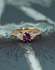 The Desir Ring, a custom sapphire and diamond engagement ring, elegantly displayed on a soft-colored surface. Designed in Canada.