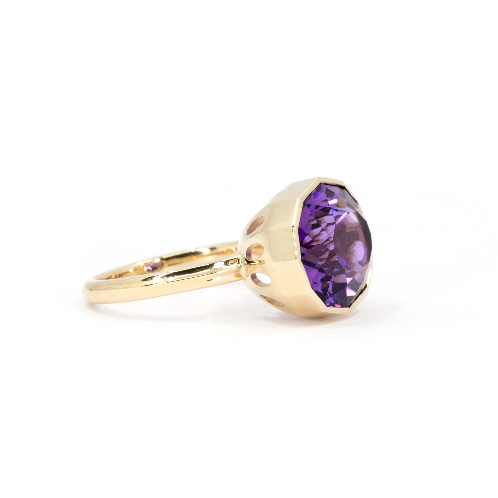 Striking amethyst ring featuring a bezel-set gemstone with purple and pink tones, showcased on a clean white backdrop.