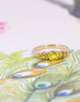 Detailed view of the yellow gold diamond band, complementing the engagement ring, displayed against a floral background.