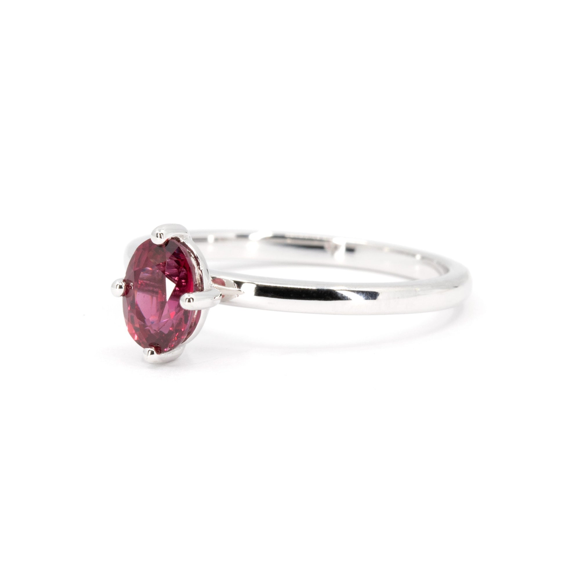 Close-up of vivid ruby gemstone in a four-prong setting on a sleek white gold band, crafted in Montreal.