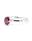 Close-up of vivid ruby gemstone in a four-prong setting on a sleek white gold band, crafted in Montreal.