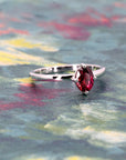 Elegant white gold ring with deep red ruby photographed on a bold color background, handmade in Montreal by Bena Jewelry.