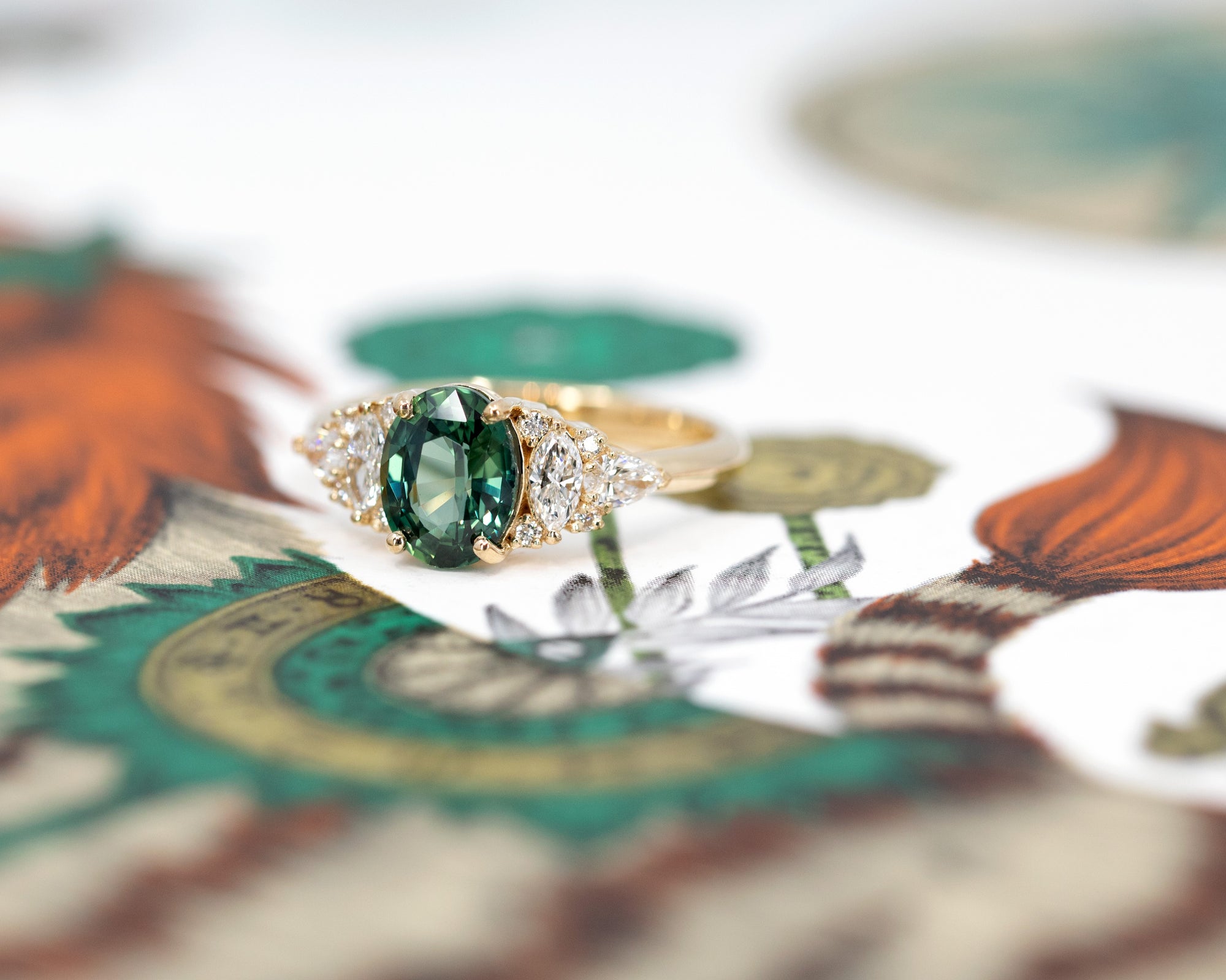 Close-up of teal sapphire ring – A vibrant teal sapphire with striking color depth, set with bezel-set diamonds for a modern, elegant look.