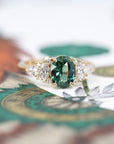 Side view of sapphire and diamond ring – The oval sapphire’s rich blue-green tones contrast beautifully with the warm yellow gold setting.
