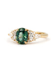 Teal Sapphire Ring on white background – The deep greenish-blue sapphire gemstone glows beautifully against a warm, neutral background.