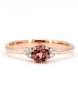 Désir ring in rose gold featuring a cushion-cut peach spinel with soft cinnamon hues, accented by side diamonds. A unique engagement ring handmade in Montreal by Bena Jewelry.