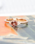 The Désir ring glows in a colorful setting, emphasizing the unique blend of its peach spinel, diamond accents, and luxurious rose gold craftsmanship.