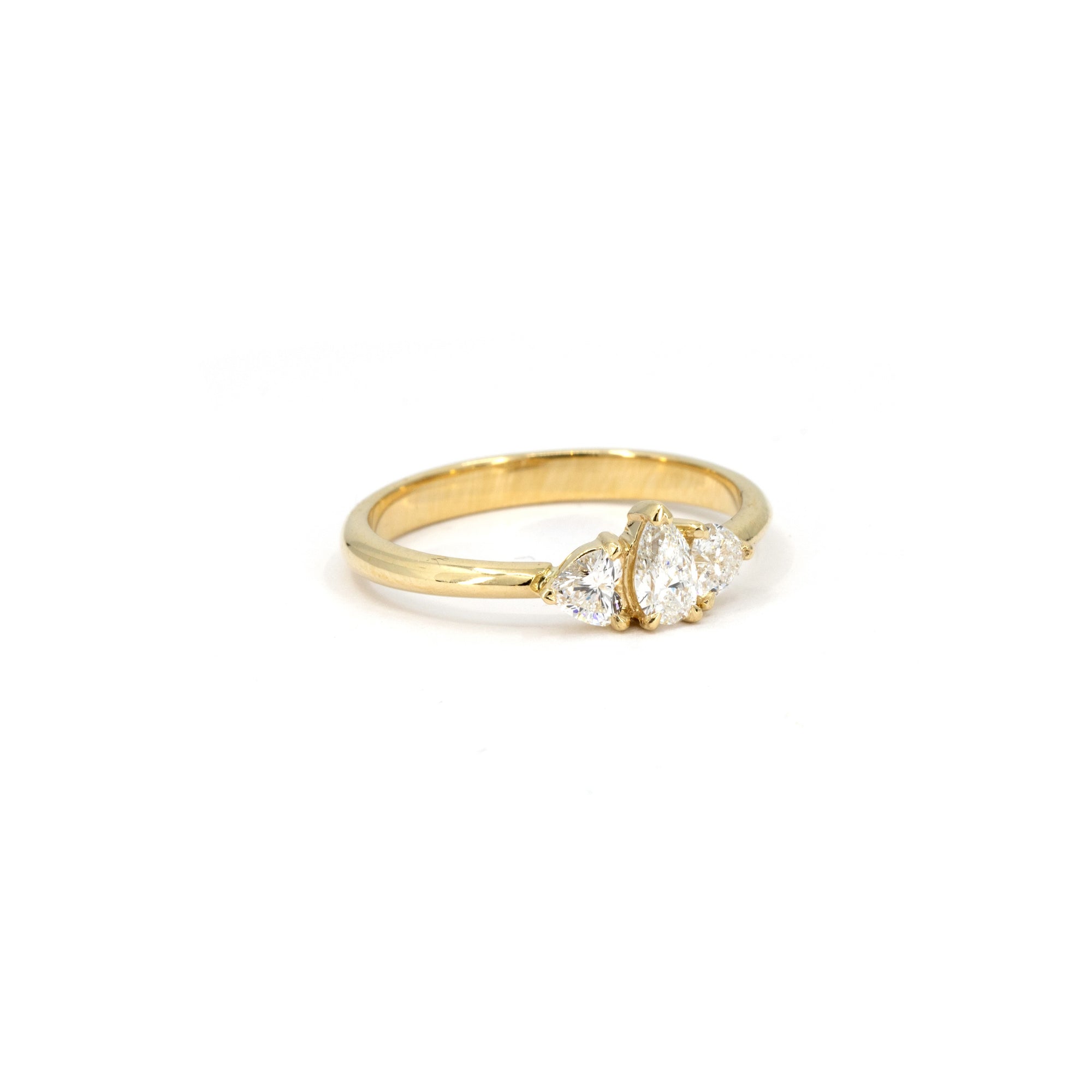 Side view of the Heart & Pear Trinity Ring, showcasing its refined gold band and elegant diamond setting.