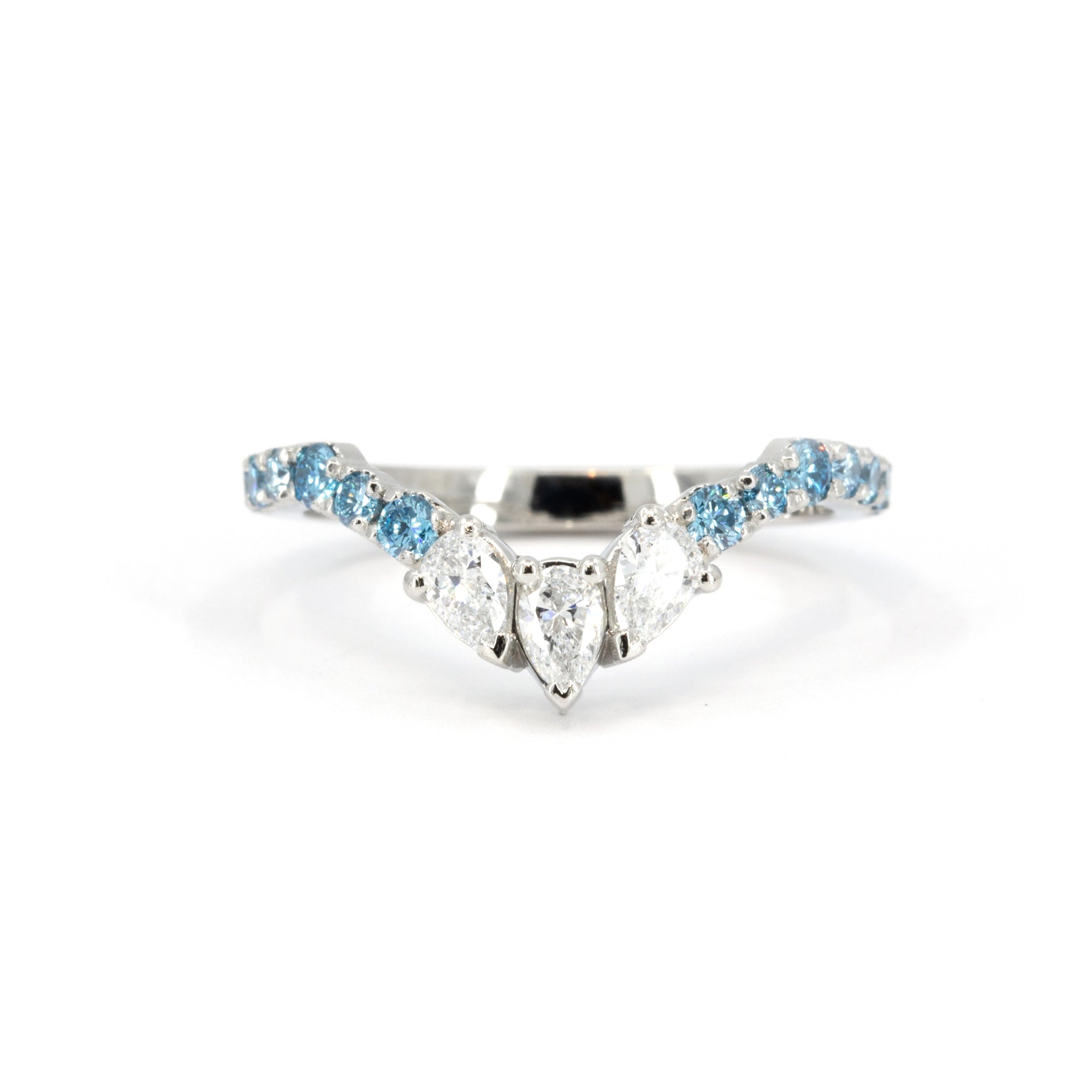 The Blue Mirage ring photographed on a soft-colored background, emphasizing the contrast between blue diamonds and platinum.