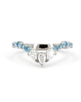 The Blue Mirage ring photographed on a soft-colored background, emphasizing the contrast between blue diamonds and platinum.