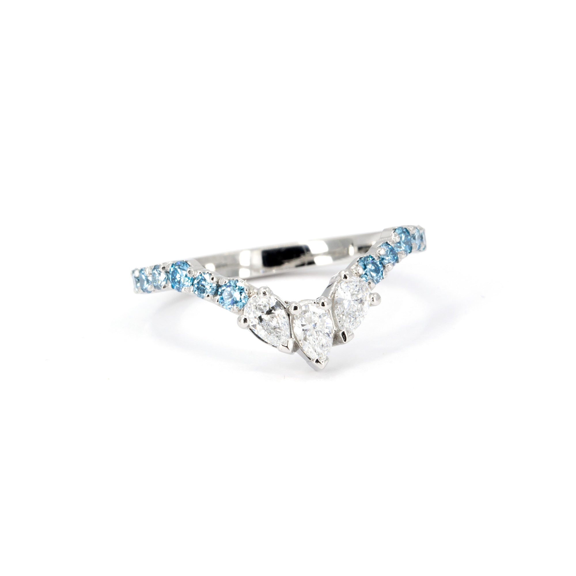 Close-up of the pear-shaped white diamonds at the center of the curved platinum band, handmade in Montreal.