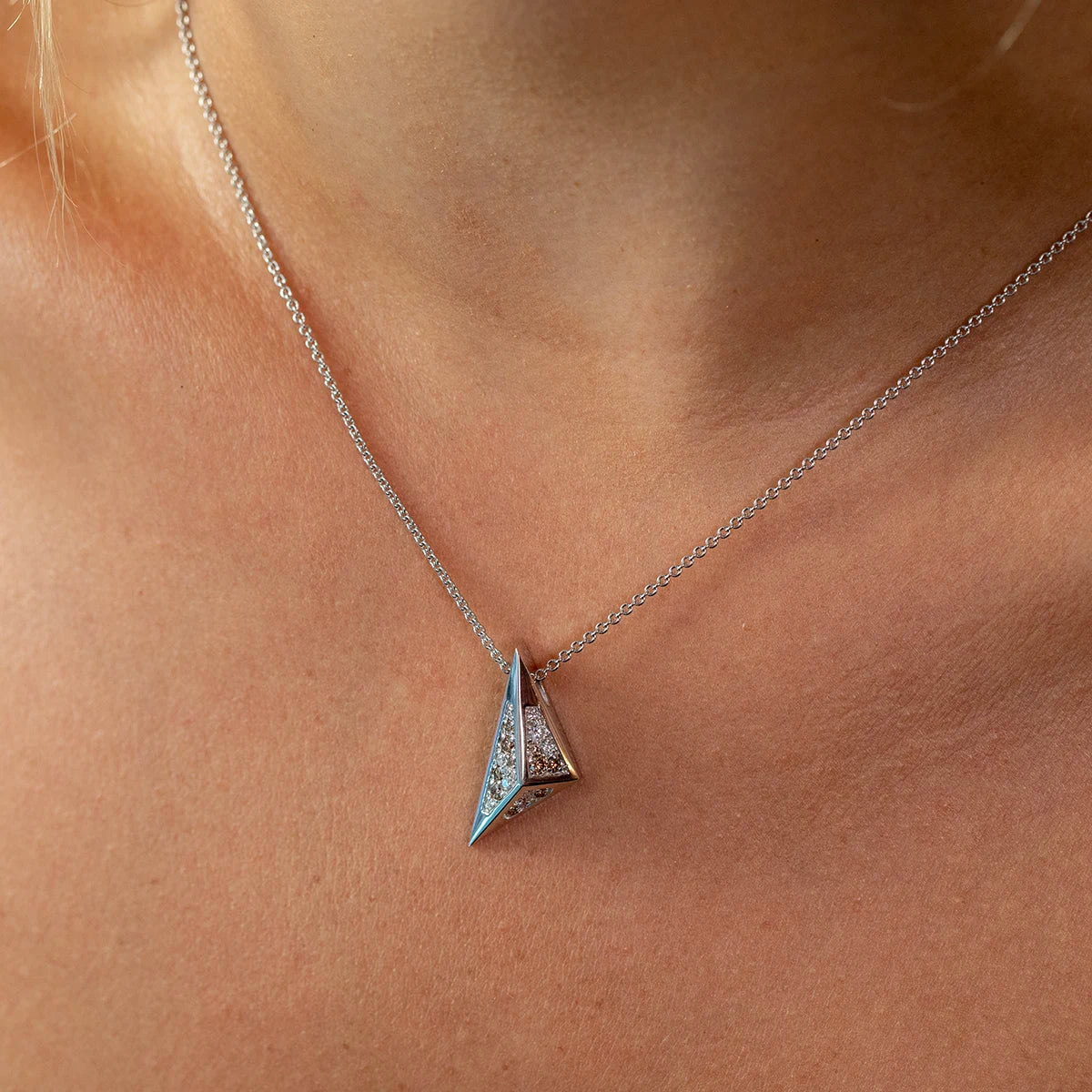 Close-up of the Bena Jewelry Pyramid Pendant in white gold, featuring a powerful angular design and a mix of sparkling white and champagne diamonds, embodying strength, edge, and modern elegance.