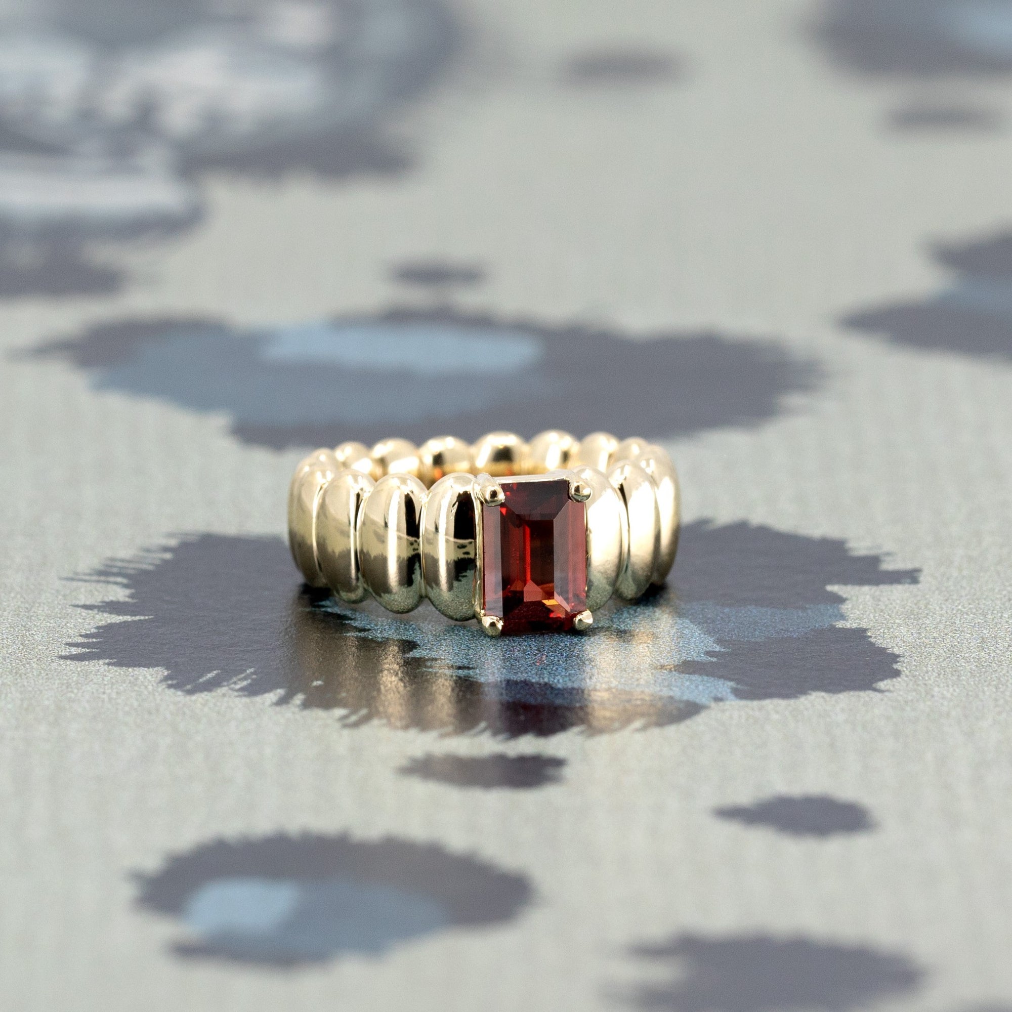 Side profile of the Pyrope Pigalle Ring, highlighting the gemstone’s depth, the polished yellow gold band, and its contemporary design, crafted in Canada, by Bena Jewelry.