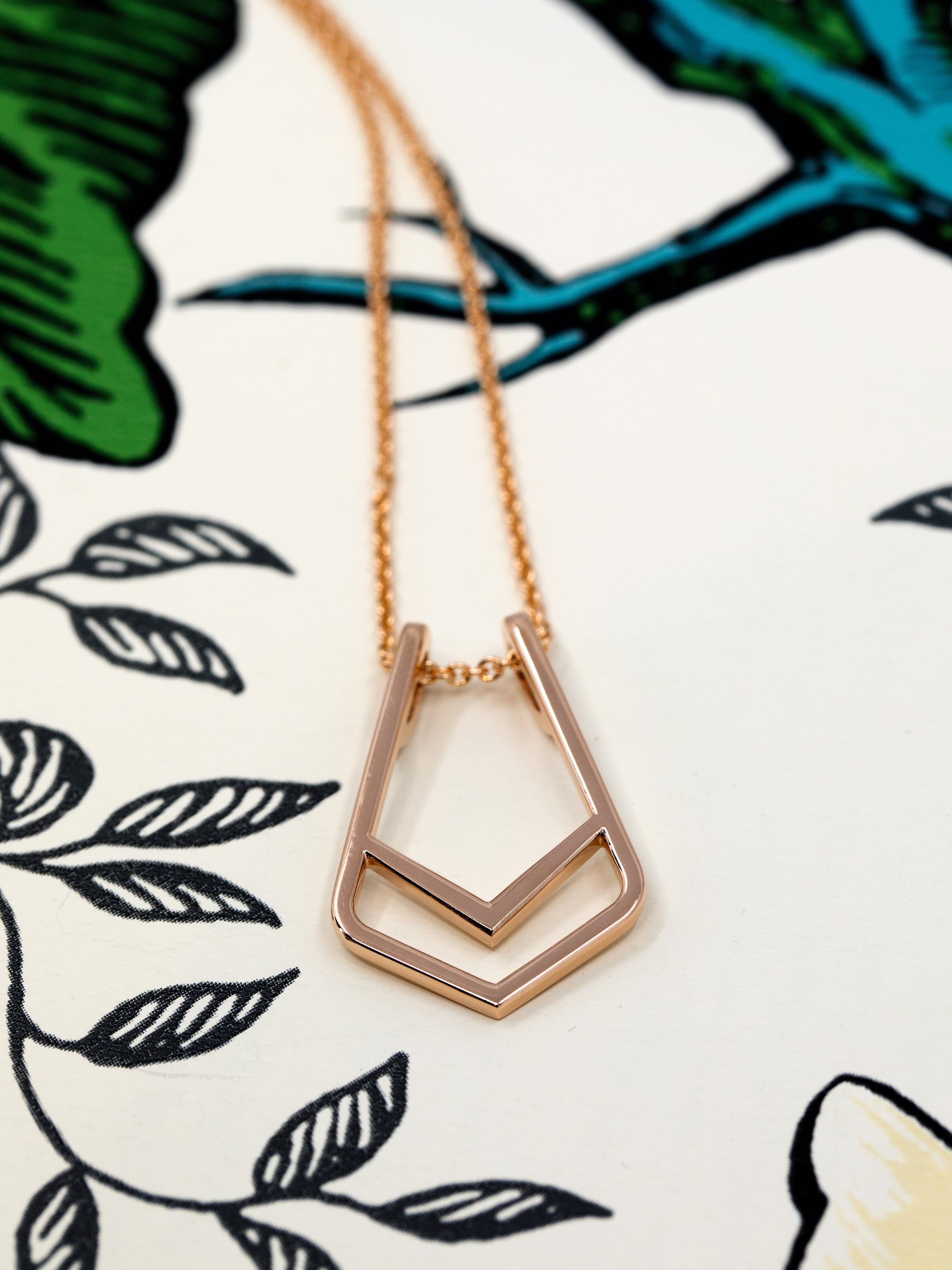 Angled shot of Ring Holder Pendant in Rose Gold – A high-polish pendant with a modern geometric form.