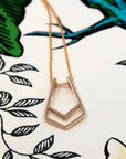 Angled shot of Ring Holder Pendant in Rose Gold – A high-polish pendant with a modern geometric form.