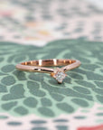 Side view of curved rose gold ring with Asscher diamond, a refined and minimalist fine jewelry piece by Bena Jewelry, Montreal.