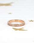 Rose gold wedding band with pinpoint-set lab-grown diamonds, worn on the hand to showcase its brilliant shine. Perfect for stacking with other rings, handcrafted by Bena Jewelry in Montreal.