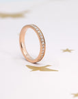 Flat lay featuring Bena Jewelry’s rose gold wedding band with pinpoint-set lab-grown diamonds, paired with other stacking rings. Handcrafted in Montreal, Quebec, for a luxurious, personalized ring collection.