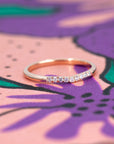 Luna Band – A delicate rose gold curved diamond ring displayed on a soft-toned background. Handmade by Bena Jewelry, an independent jewelry designer from Montreal.