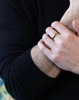 Men wearing a sleek yellow gold wedding ring with a polished dome design, custom-made by Bena Jewelry in Montreal, Canada for a refined and classic style.