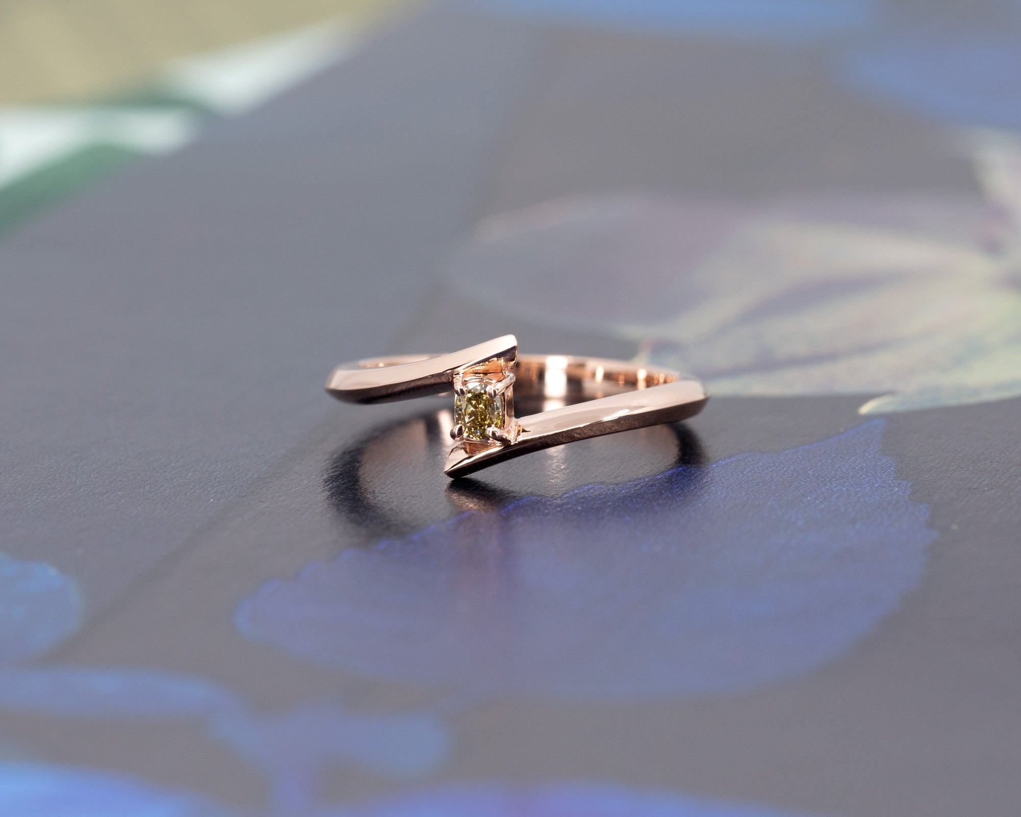 Unique Kink Yellow Diamond Ring with a cushion-cut yellow diamond, rose gold band by Bena Jewelry, showcased on a dramatic dark background. Made in Montreal.