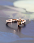 Minimalist engagement ring featuring a natural yellow diamond in rose gold by Bena Jewelry, displayed on a black matte background. Custom-made in Canada.